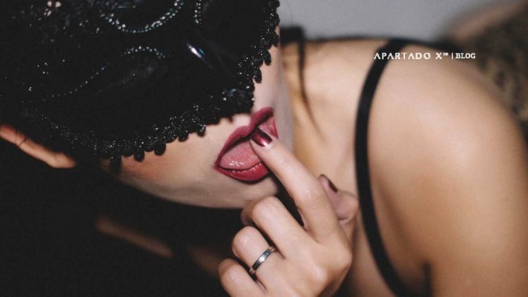 Mulher a lamber o dedo. Lábios vermelhos e mascara preta a tapar os olhos. chocolate com sexo
