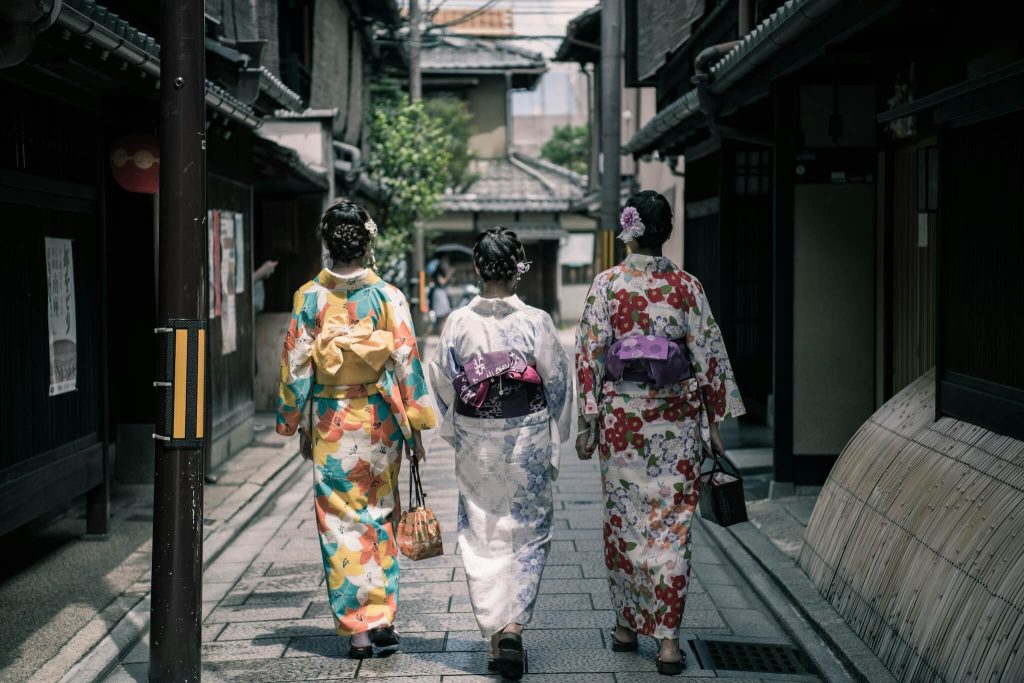 três mulheres vestidas com um quimono