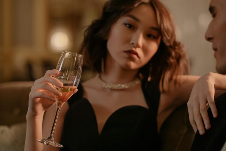 mulher sensual sentada num bar a segurar um flute de espumante