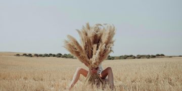 mulher num campo escondida atrás de pampas